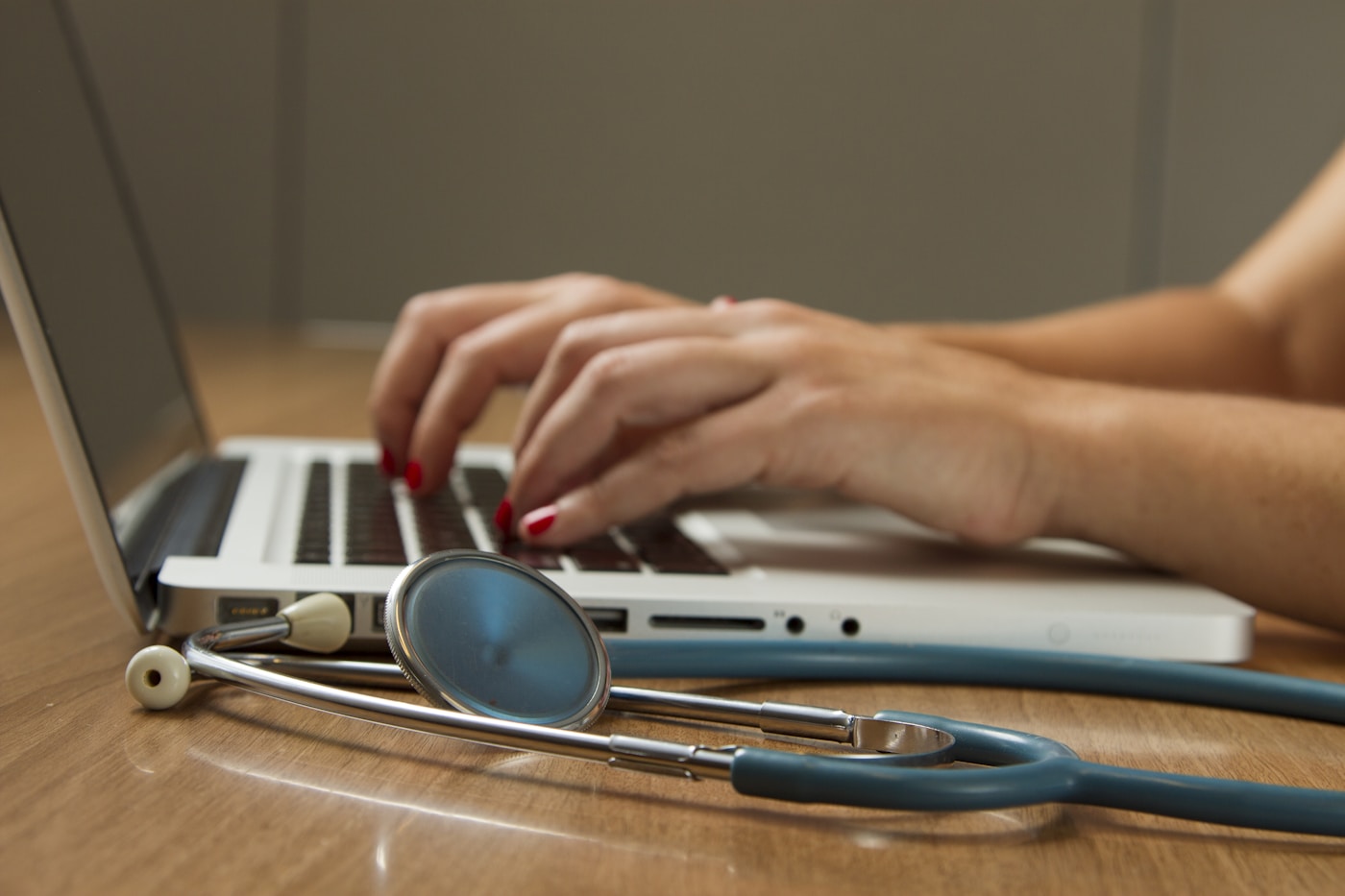 Stethoskop neben einem Laptop am Arbeitsplatz der Ärztin